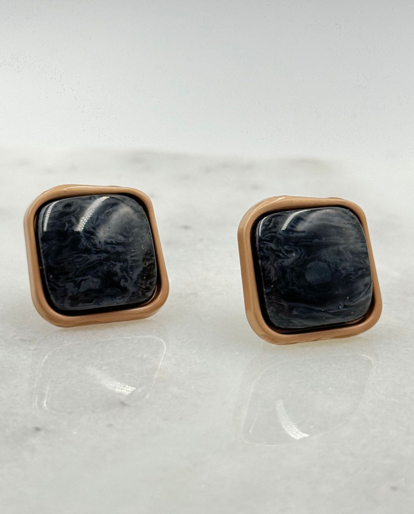 Upcycled black clip-on earrings with gold accents, made from vintage buttons – elegant and sustainable fashion piece